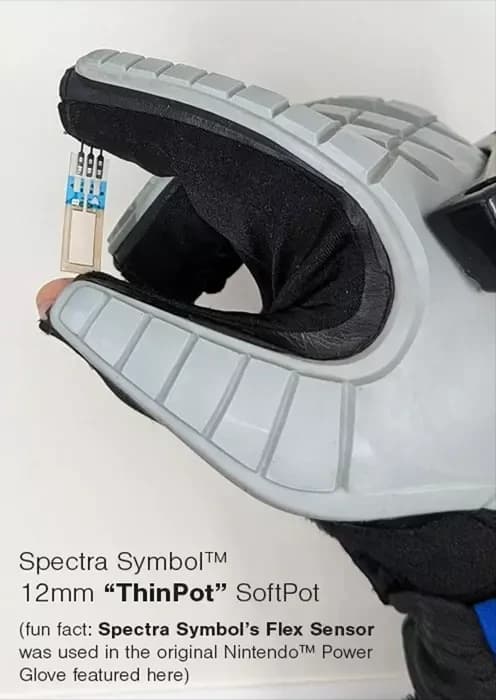 A 12 mm Spectra Symbol ThinPot SoftPot held between the fingers of a Nintendo Power Glove, with a caption noting the original Power Glove used a Spectra Symbol flex sensor.