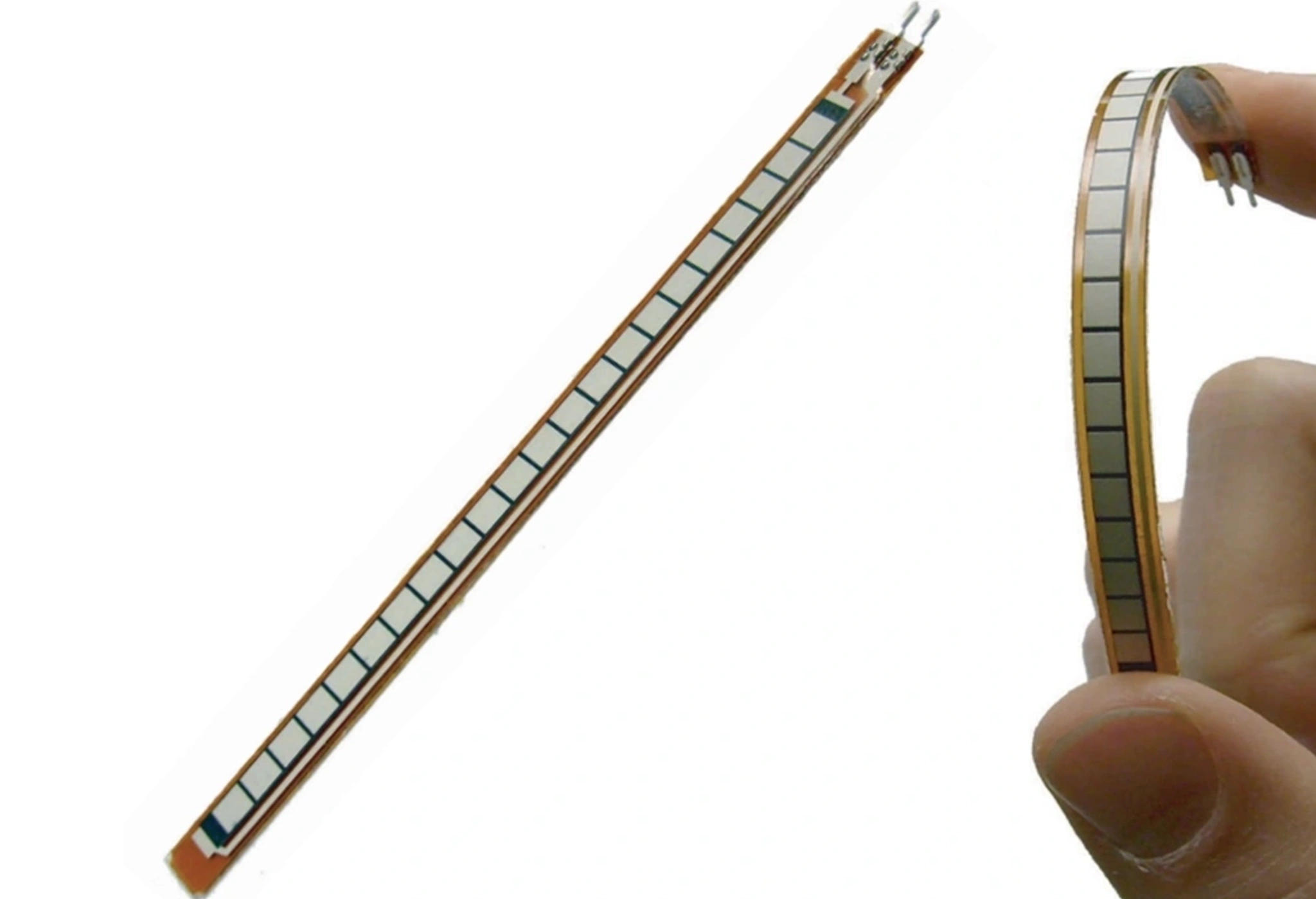 Photo showing a broad bend of a Spectra Symbol Flex Sensor held between a persons finger & thumb